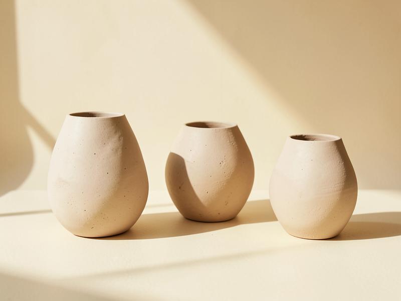 Handmade ceramic vessels on a warm cream surface